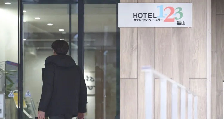 ホテル1-2-3福山 の入口に入る男性